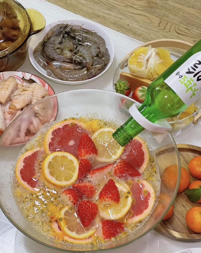 Bình soju ngâm trái cây có lát dâu tây và chanh tươi ngập tràn, sống động