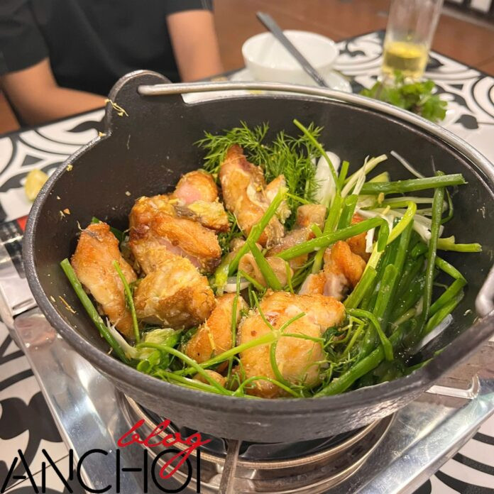Món chả cá bày trong chảo gang, kèm rau thì là và hành lá tại nhà hàng Vua chả cá